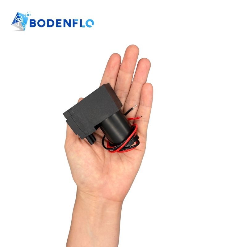 Compact BD-03AB 24V diaphragm air pump shown in hand for size reference